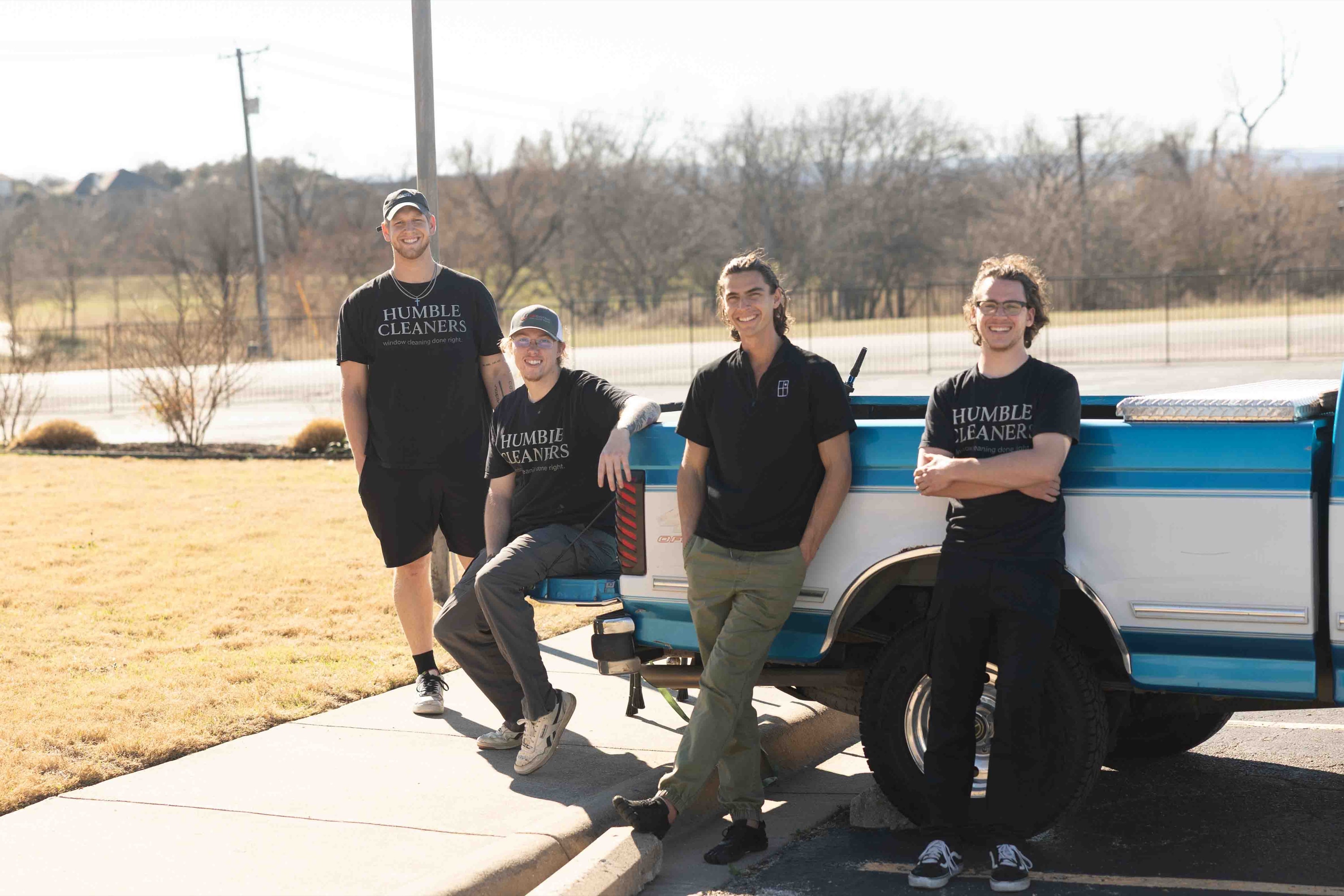 The Humble Cleaners crew in their company shirts, leaning against their blue and white pickup truck in Keller, Texas